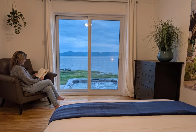 Lecture dans un chalet avec vue sur le fleuve